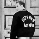 Photo of Scott Gaynor from the 90s facing away from the camera wearing a jacket that has the words "Stephen Gaynor" on the back