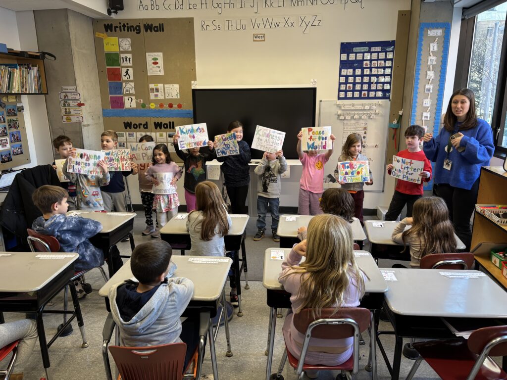 EC students presenting the signs they created on the issues they wanted to "speak up" about to Red Cluster students.